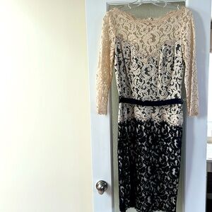 Lace fitted dress, cream top with black bottom, ribbon belt. Hits below knee